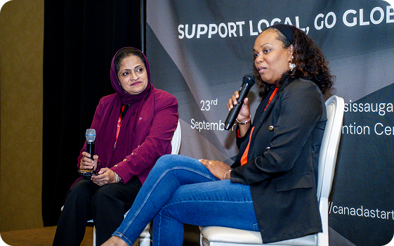 Tehmina speaking on stage at the Support Local, Go Global event